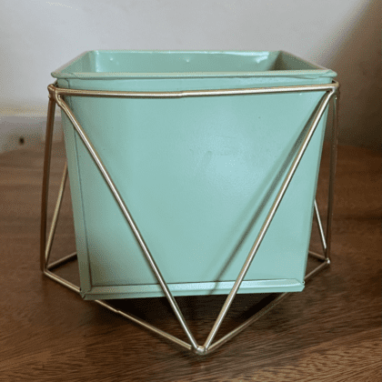 pastel green metal pot on a gold-coloured metal stand