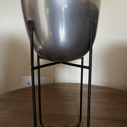 silver metal pot on a tall black stand